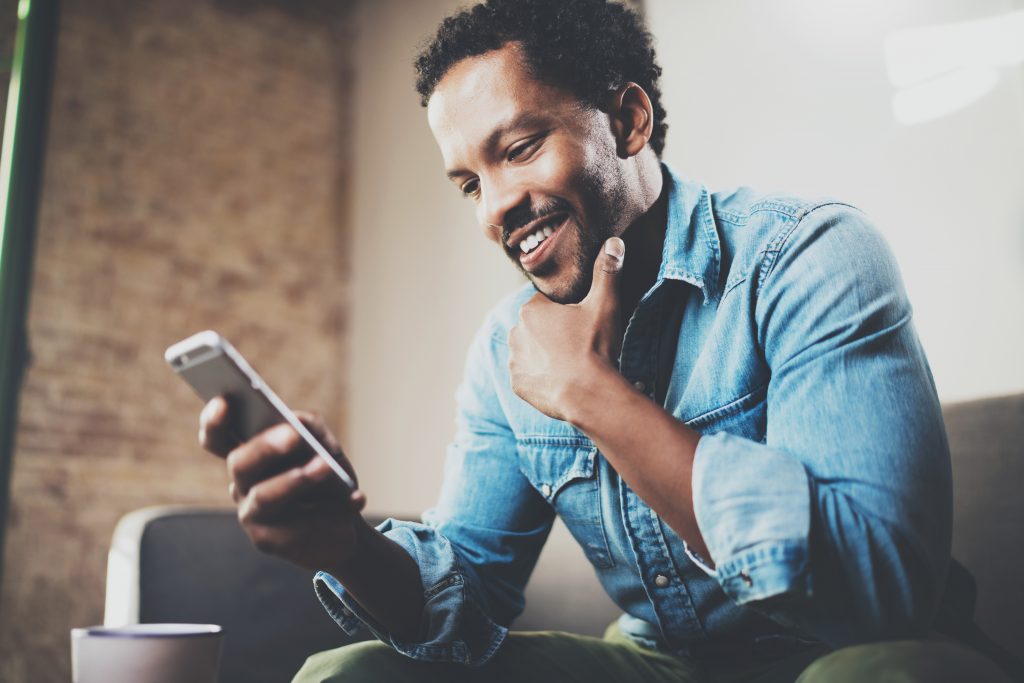 Image of man smiling at mobile phone